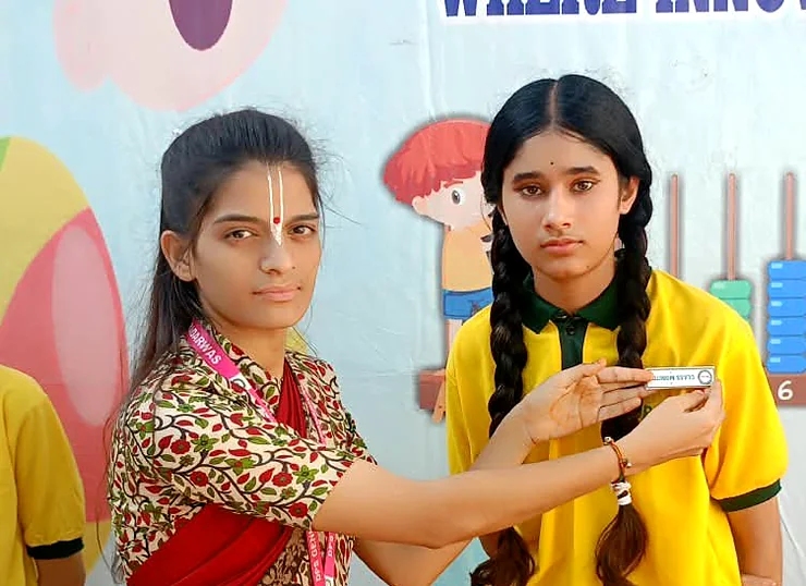 A teacher pinning a badge on a student